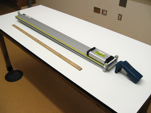 low-friction track and cart with a meterstick next to it, a spacer under the foot of the track, and motion detector at the opposite end of the track